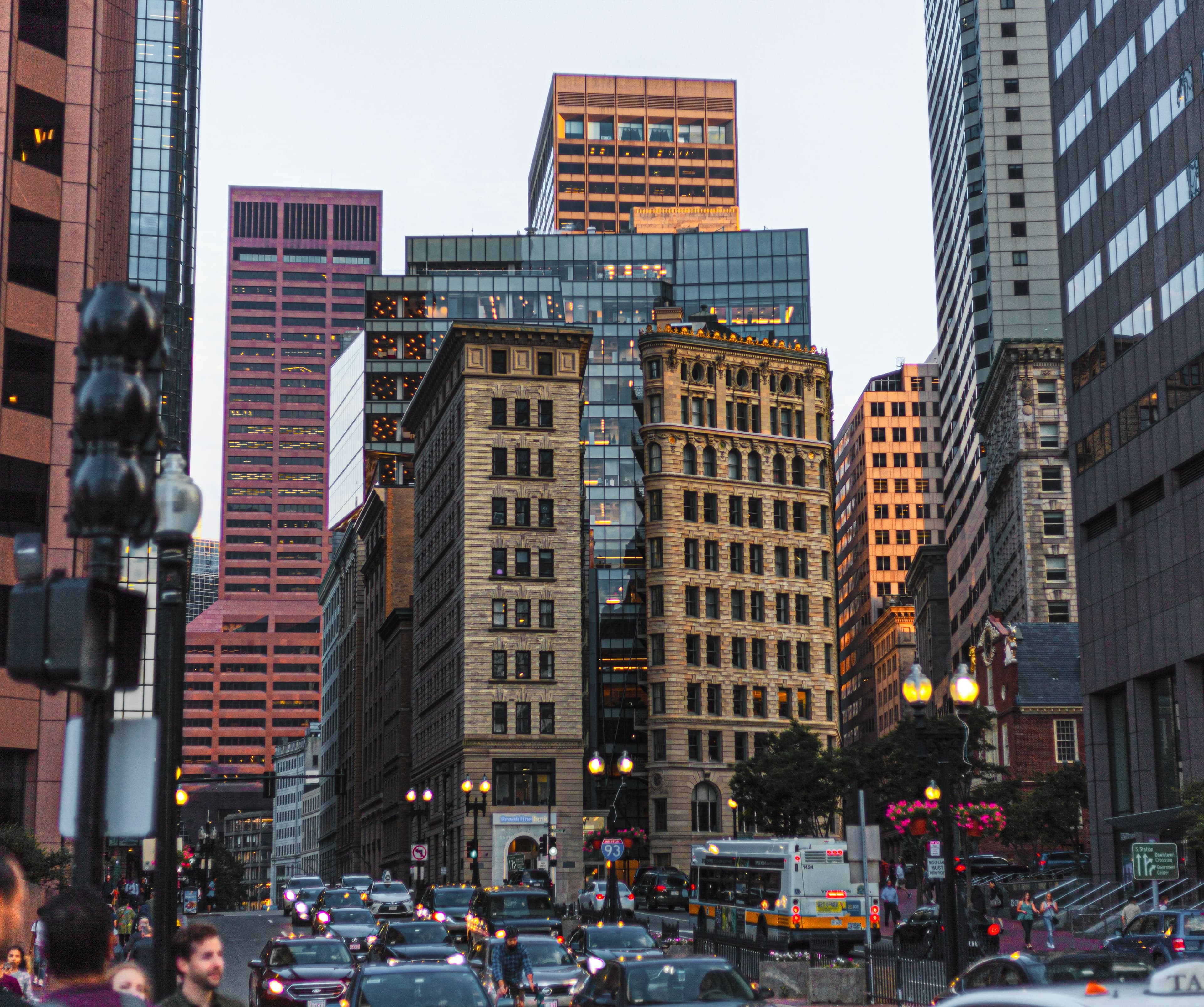 Downtown Boston at dusk, a busy city street lined with historic and modern buildings