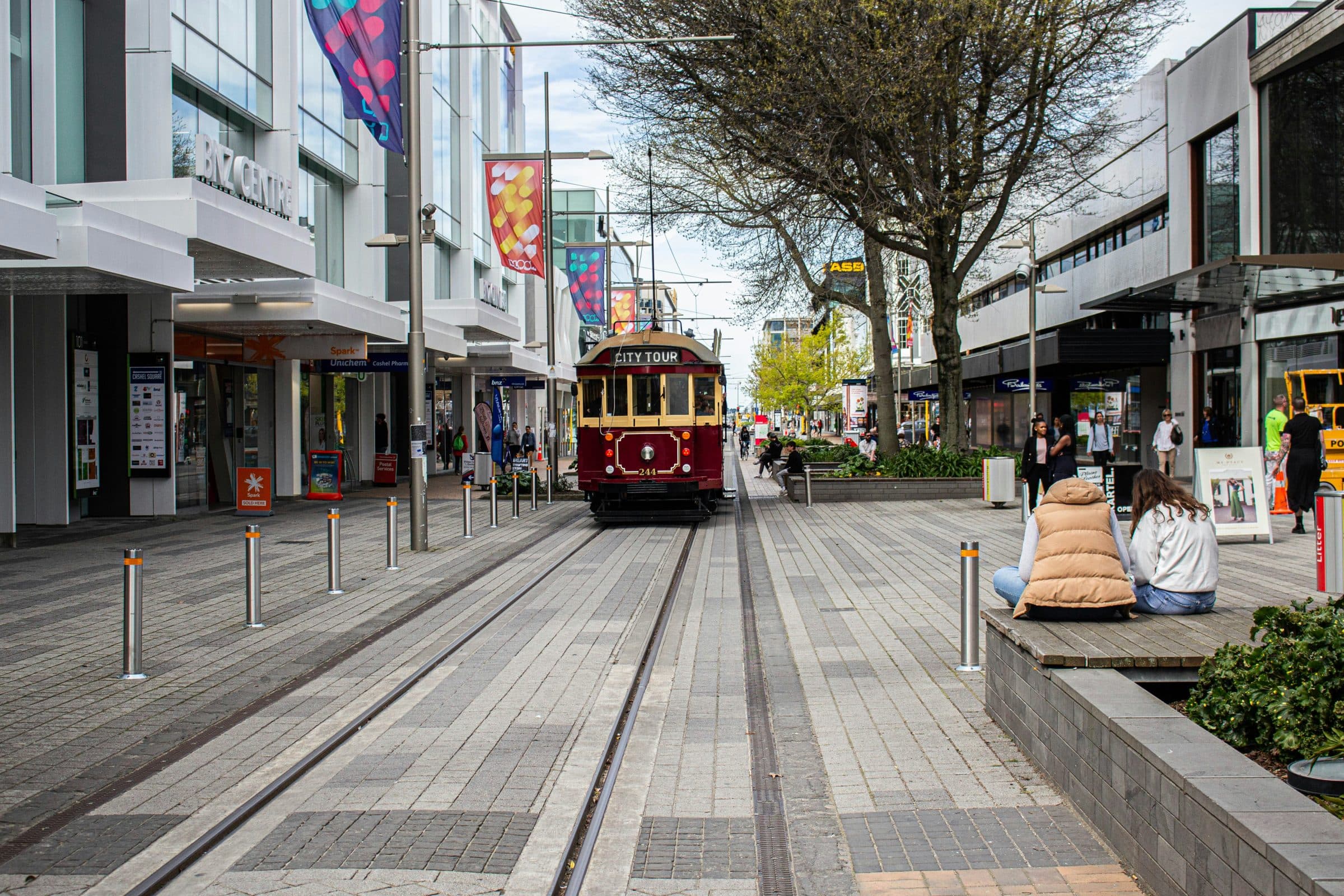 A red City Tour heritage tram running along the pedestrian precinct of Cashel Mall in central Christchurch, about a kilometre from the marathon finish in North Hagley Park