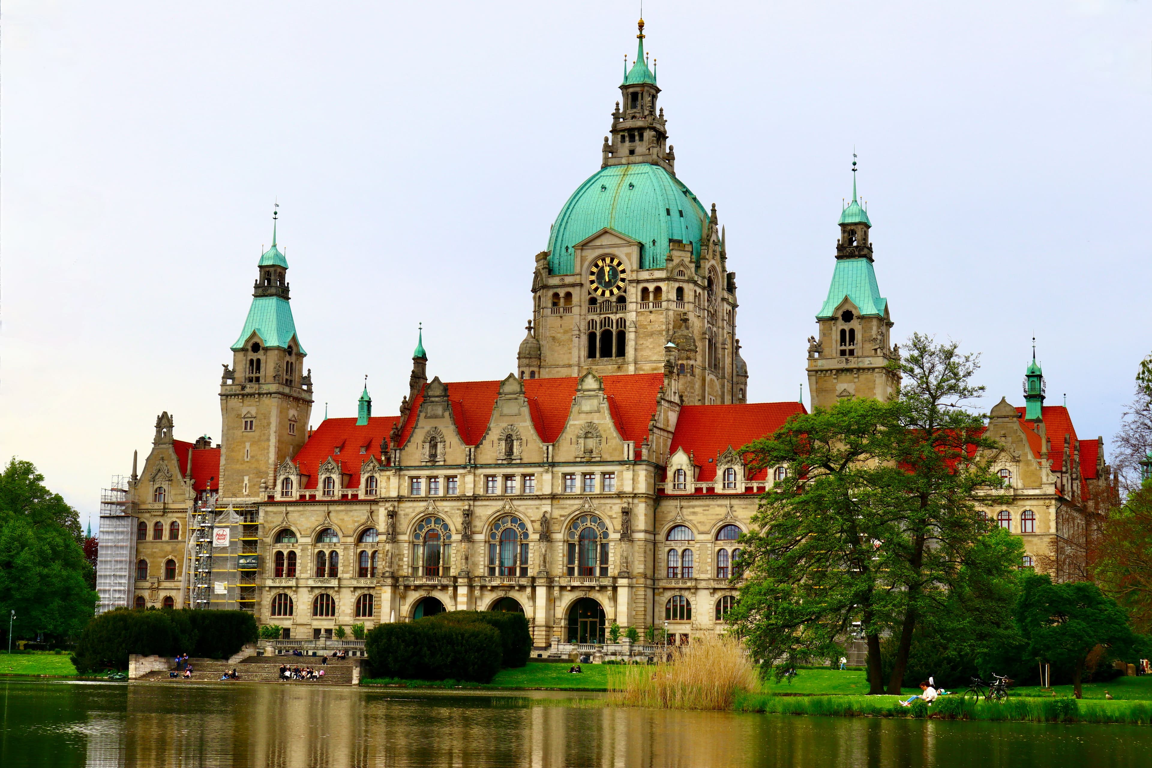 The Neues Rathaus in Hannover seen across the Maschteich in Maschpark, its green copper dome and red roofs above the water, the building beside which the ADAC Marathon Hannover starts and finishes on Friedrichswall
