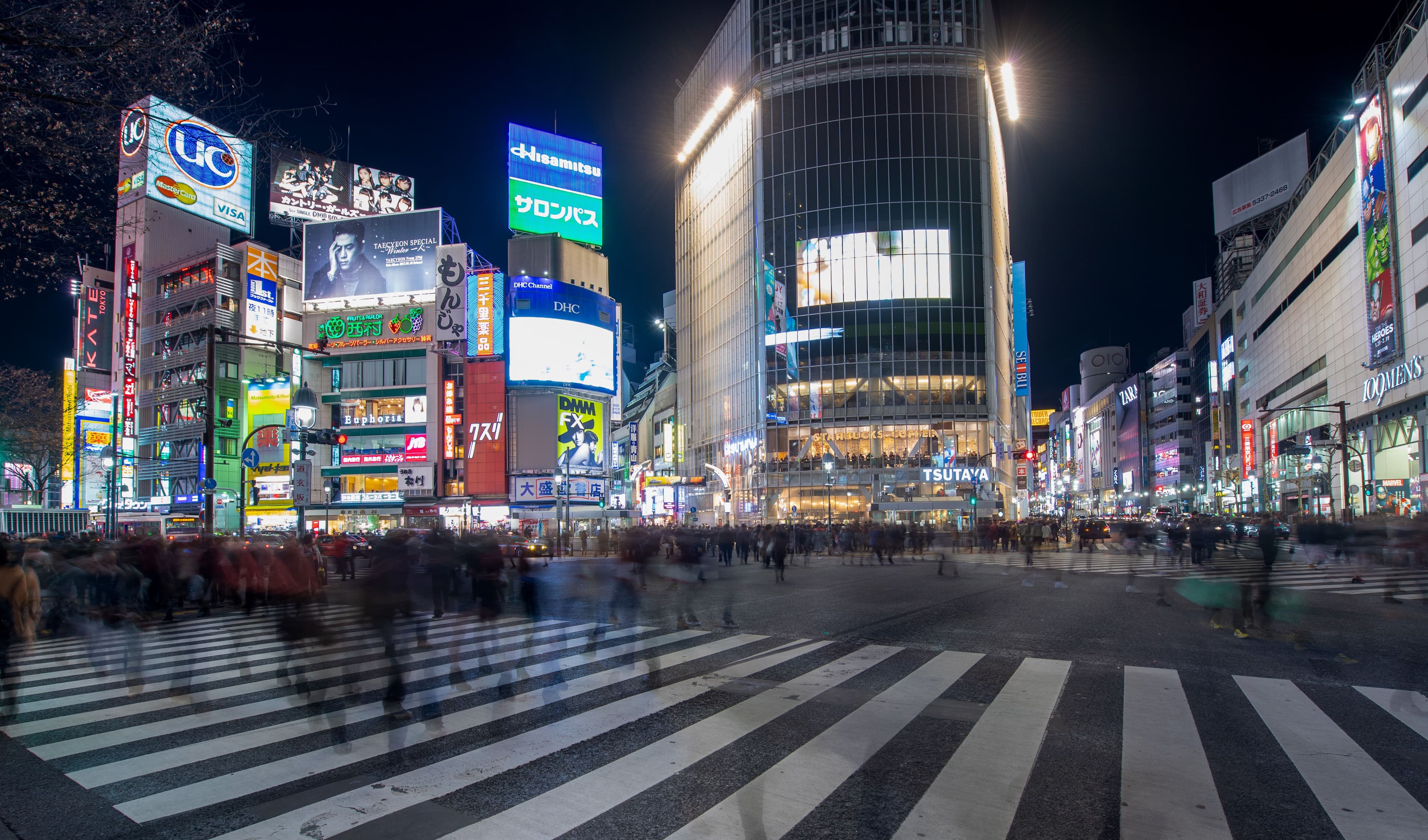 Shibuya Crossing at night, Tokyo - illuminated billboards reflecting on wet streets