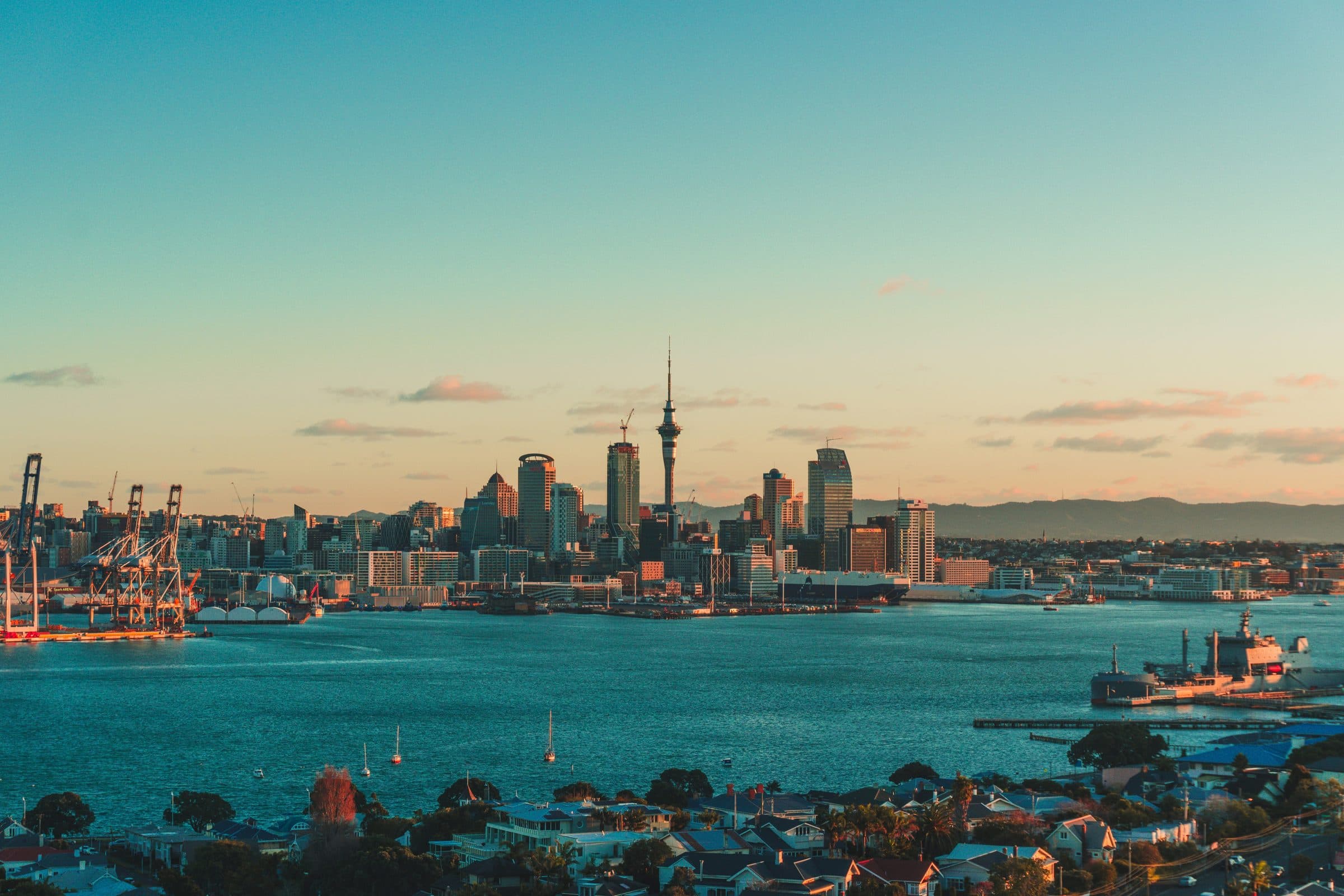 Auckland's skyline and Sky Tower across the Waitemata Harbour at dusk, seen from the Devonport shore where the marathon starts