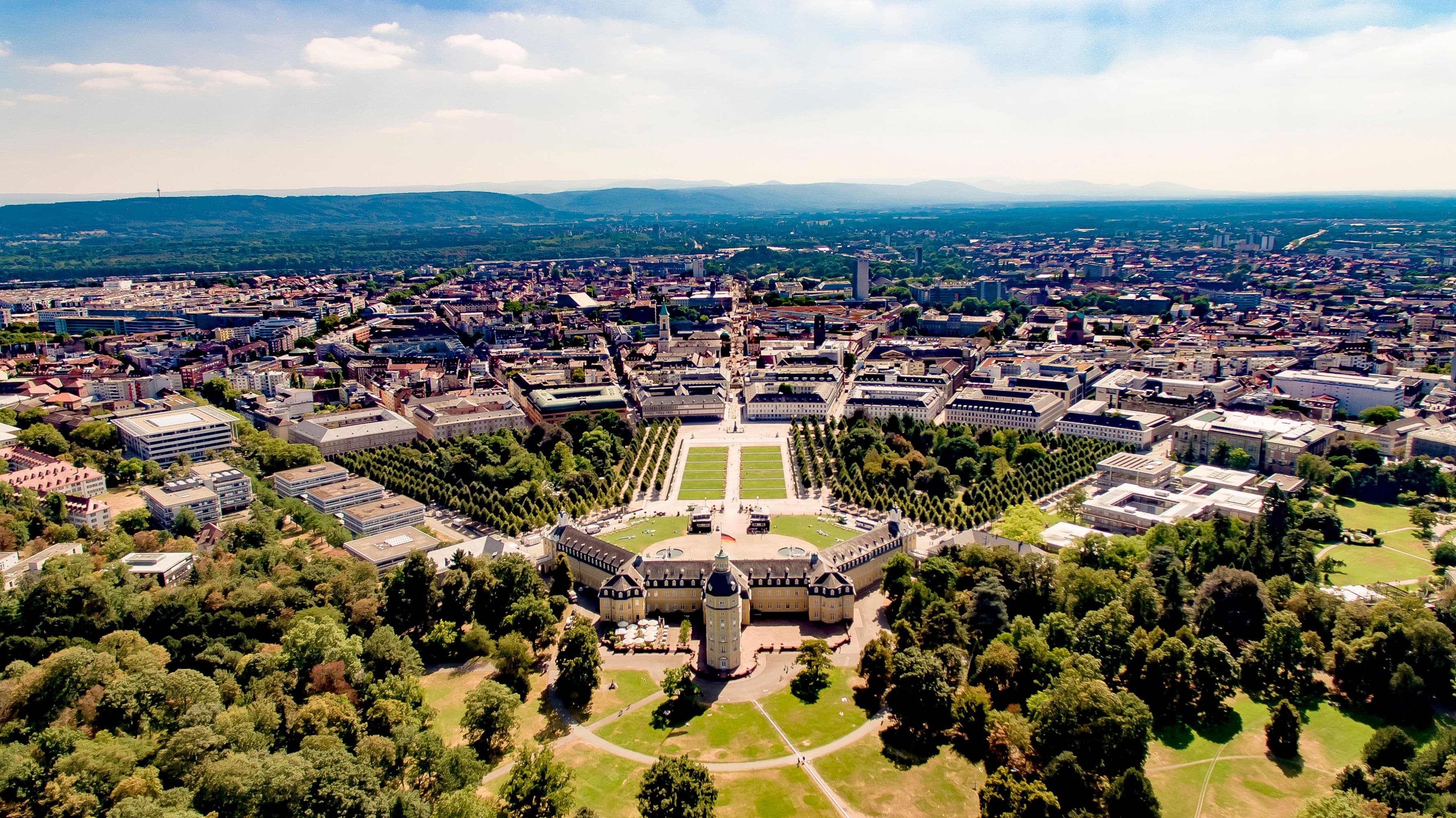 Karlsruhe Palace from the air, with the city's streets radiating out from it in a fan and the Black Forest hills on the horizon. The marathon passes the palace twice, at about km 15.7 and km 36.7.