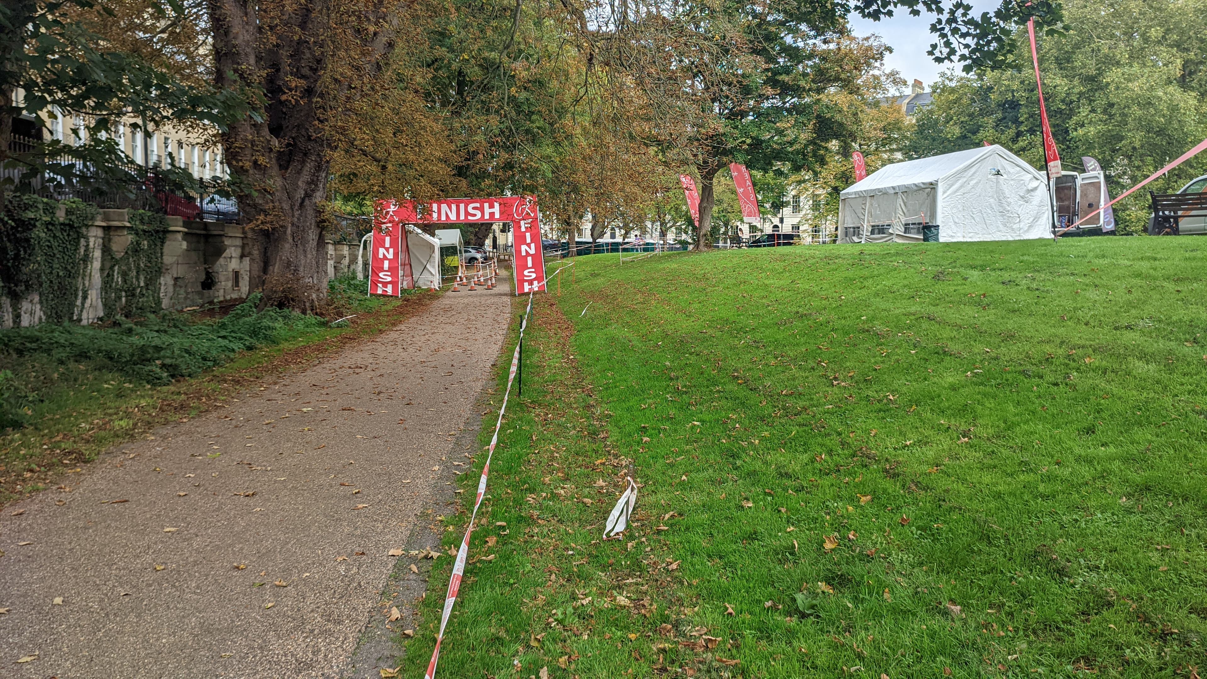 The finish gantry at Green Park, Bath, at the end of the Bath and Bristol Railway Marathon, with the bag-storage marquee and event flags visible