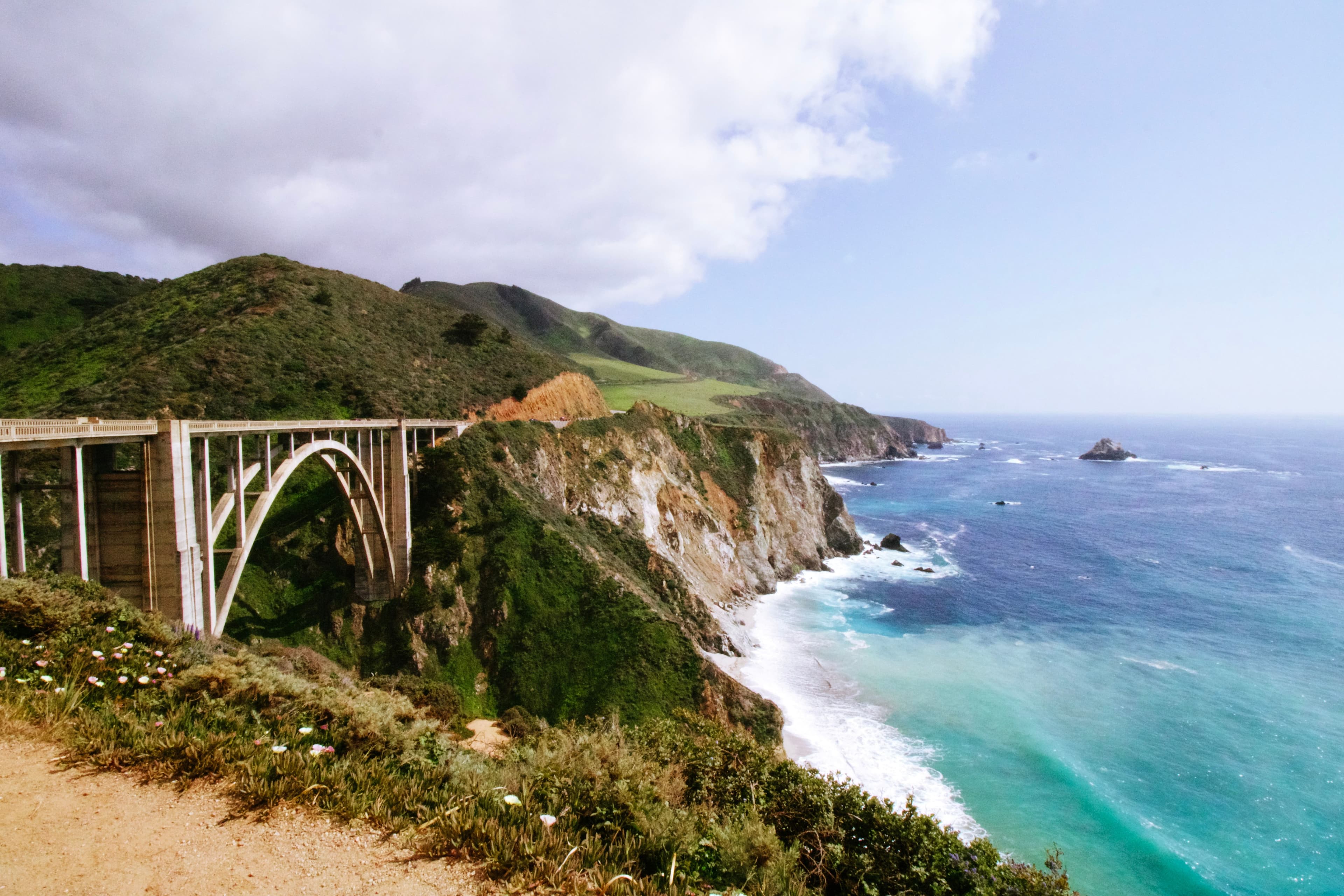 Bixby Creek Bridge on Highway 1 in Big Sur, California, with the Pacific coastline and cliffs behind it