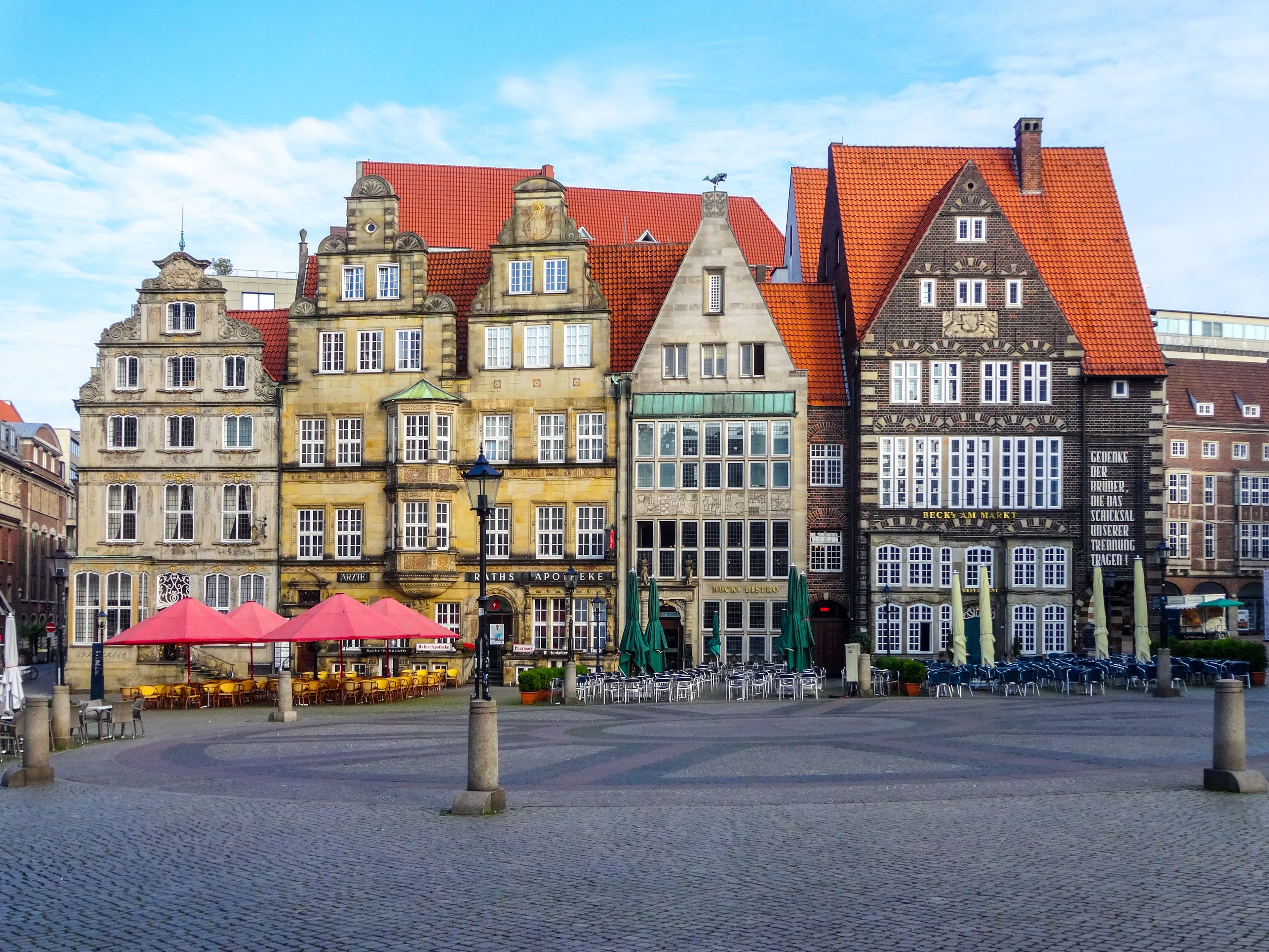 The gabled merchant houses on the west side of Bremen's Marktplatz, with cafe tables on the cobbles, the square where the swb-Marathon Bremen starts and finishes