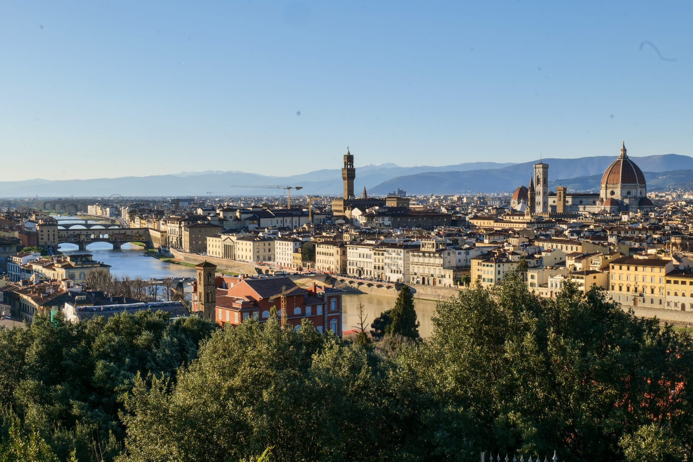 Florence seen from Piazzale Michelangelo on a clear morning, with the Ponte Vecchio on the left, the tower of Palazzo Vecchio in the centre and the dome of the Duomo on the right