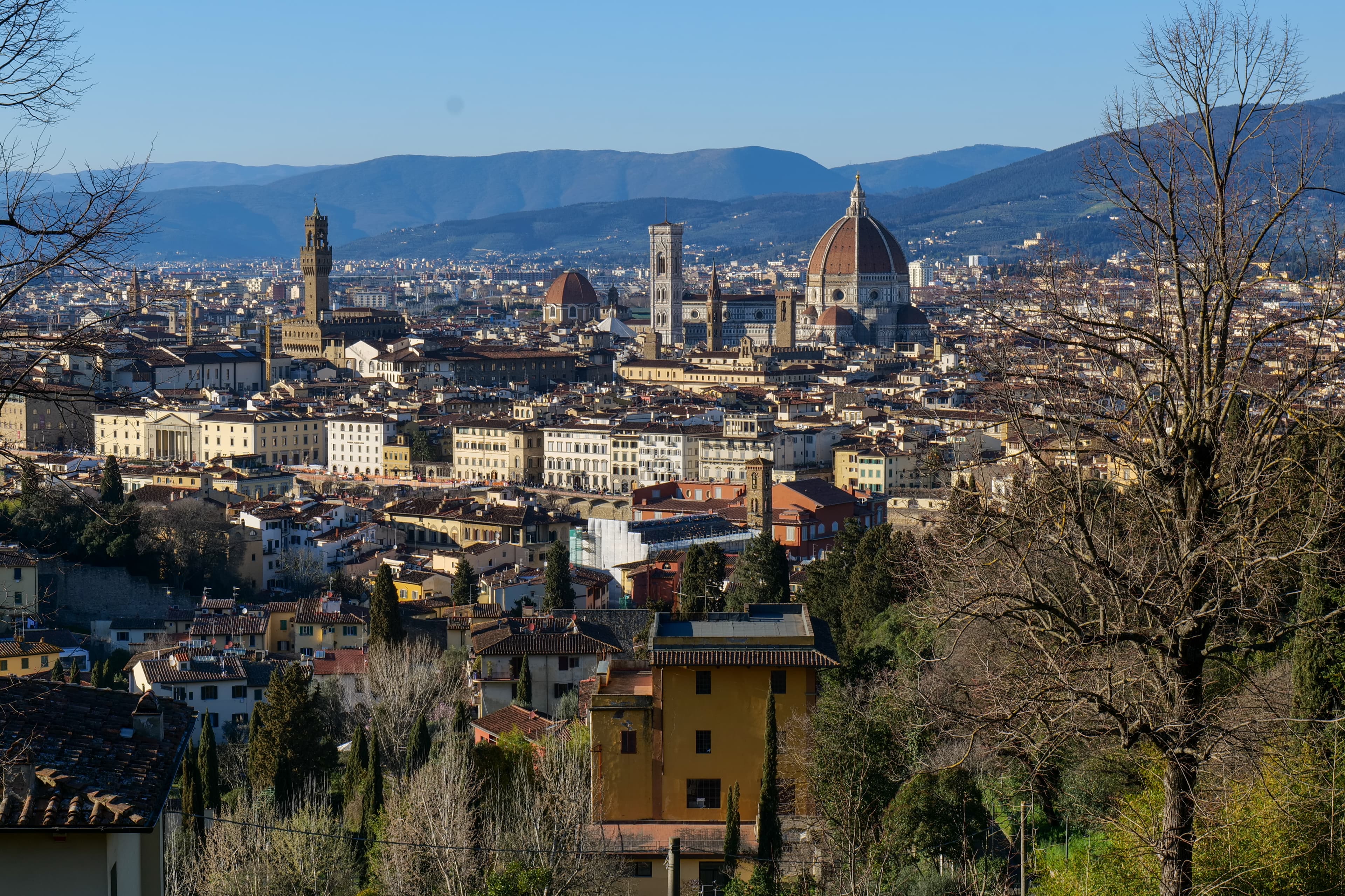 Ponte Vecchio over the Arno river in Florence, with the medieval bridge shops reflected in the still morning water
