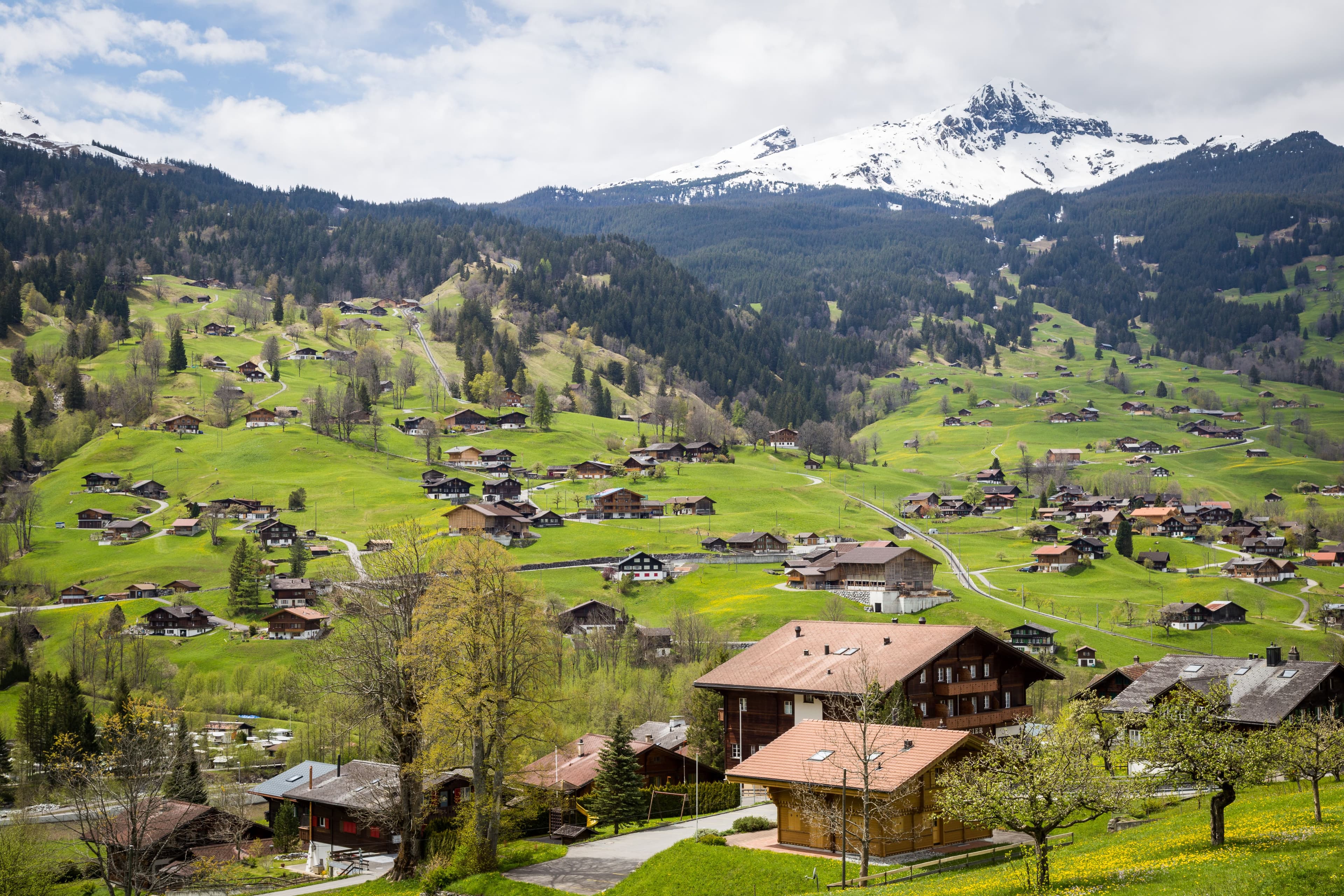 A Bernese Oberland chalet village beneath snow-capped peaks, on the route between Interlaken and the Jungfrau Marathon finish