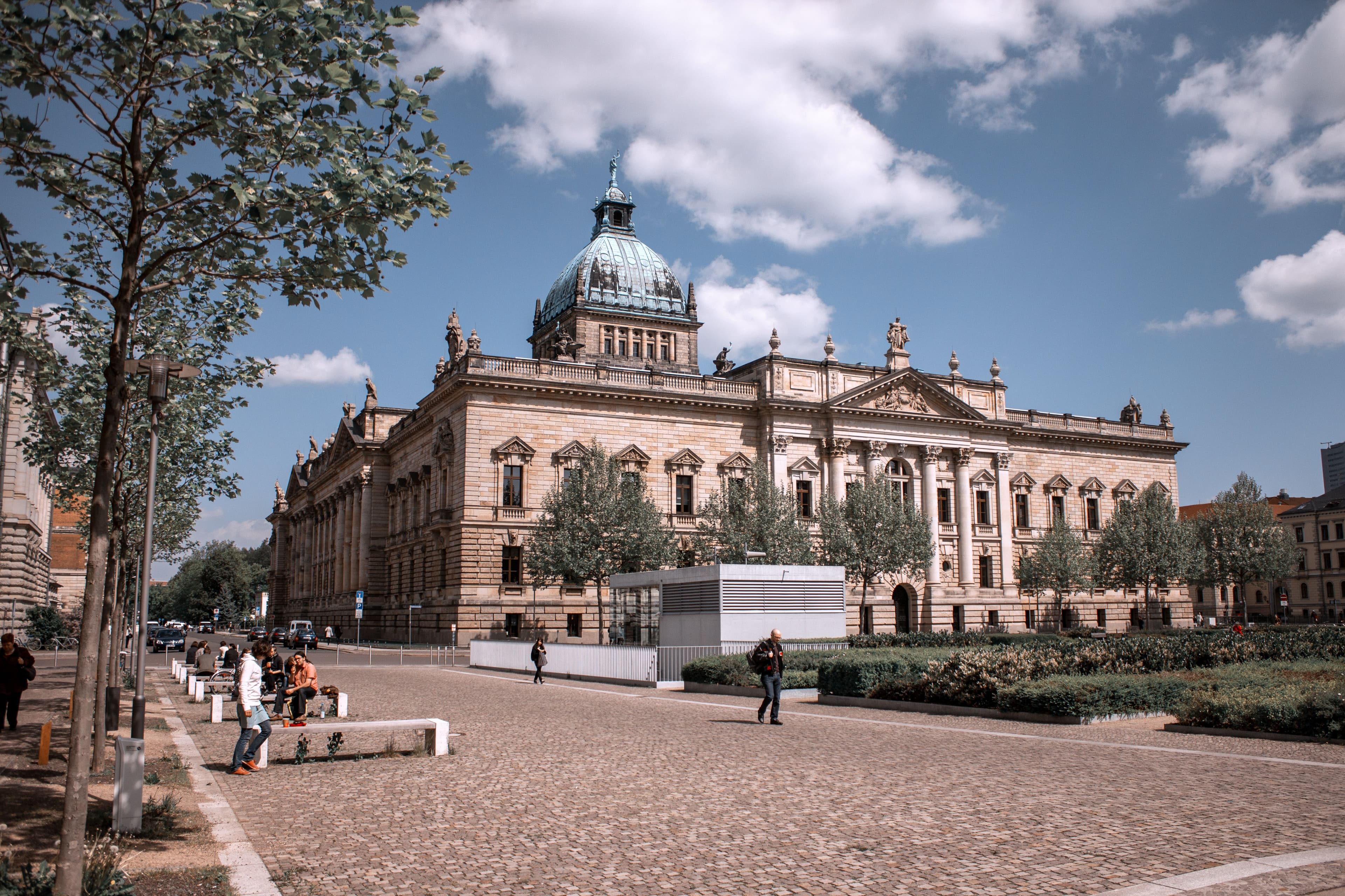The domed Federal Administrative Court building on Simsonplatz in Leipzig, the former Reichsgericht, seen across its cobbled forecourt. The marathon passes within about 150 metres of it at km 1.7 on each lap.