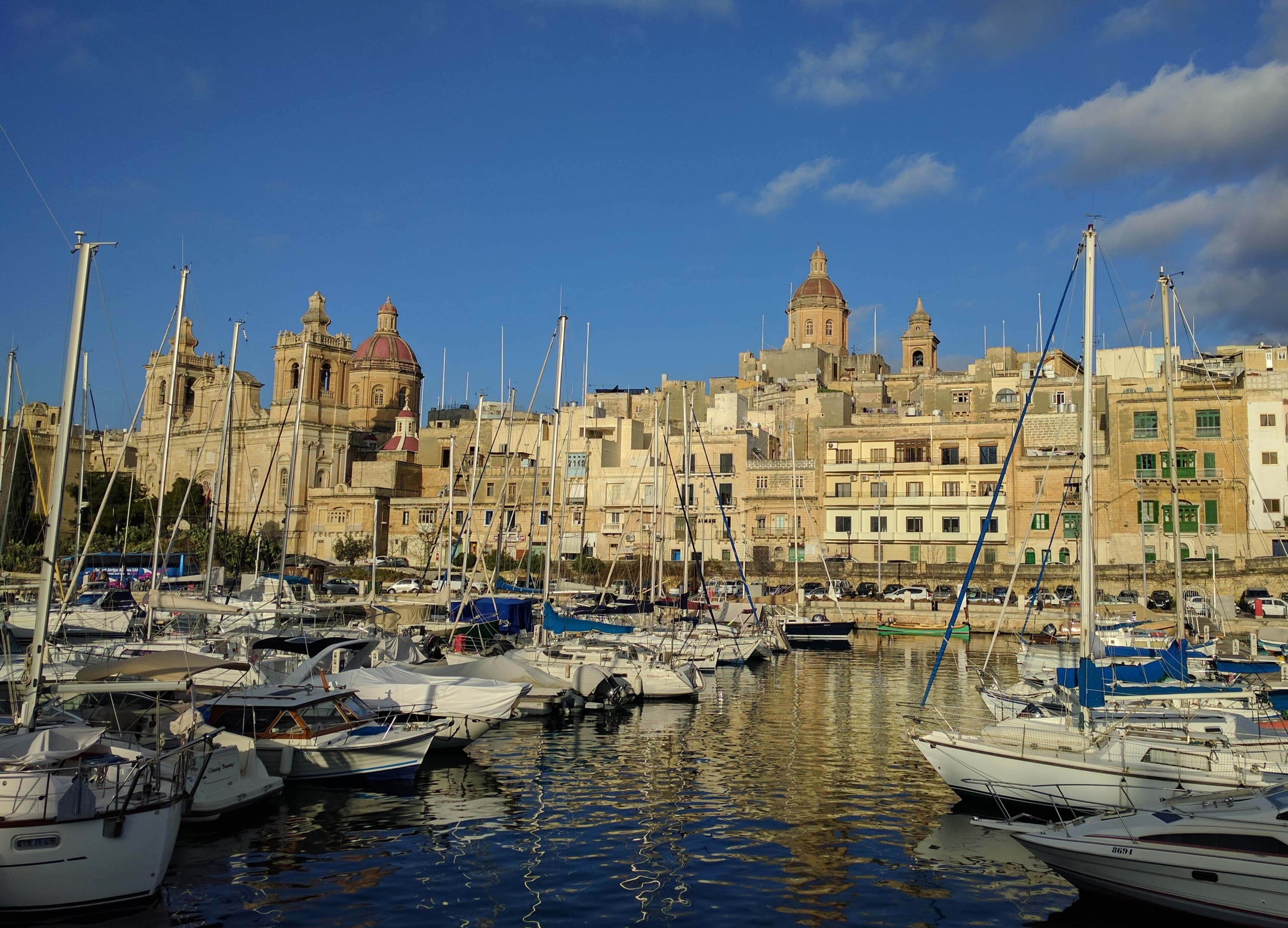Harbour view of Malta's Three Cities, with baroque church domes and yachts moored in the marina
