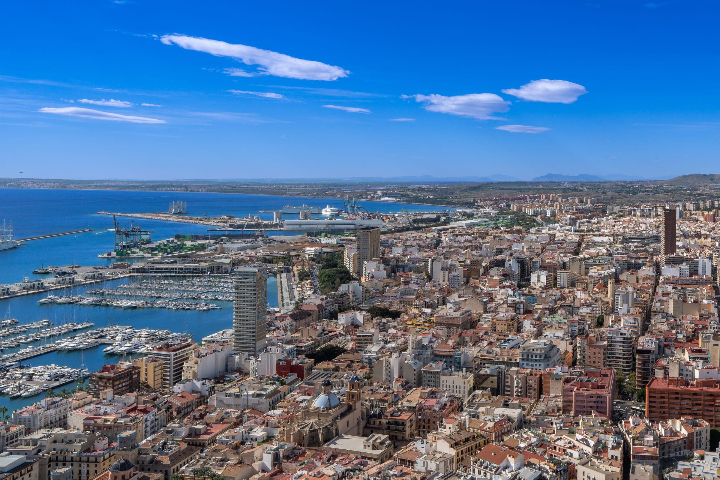 Aerial view over central Alicante to the port and marina, with the harbour breakwaters and the bay beyond, where the Maratón Elche-Alicante finishes