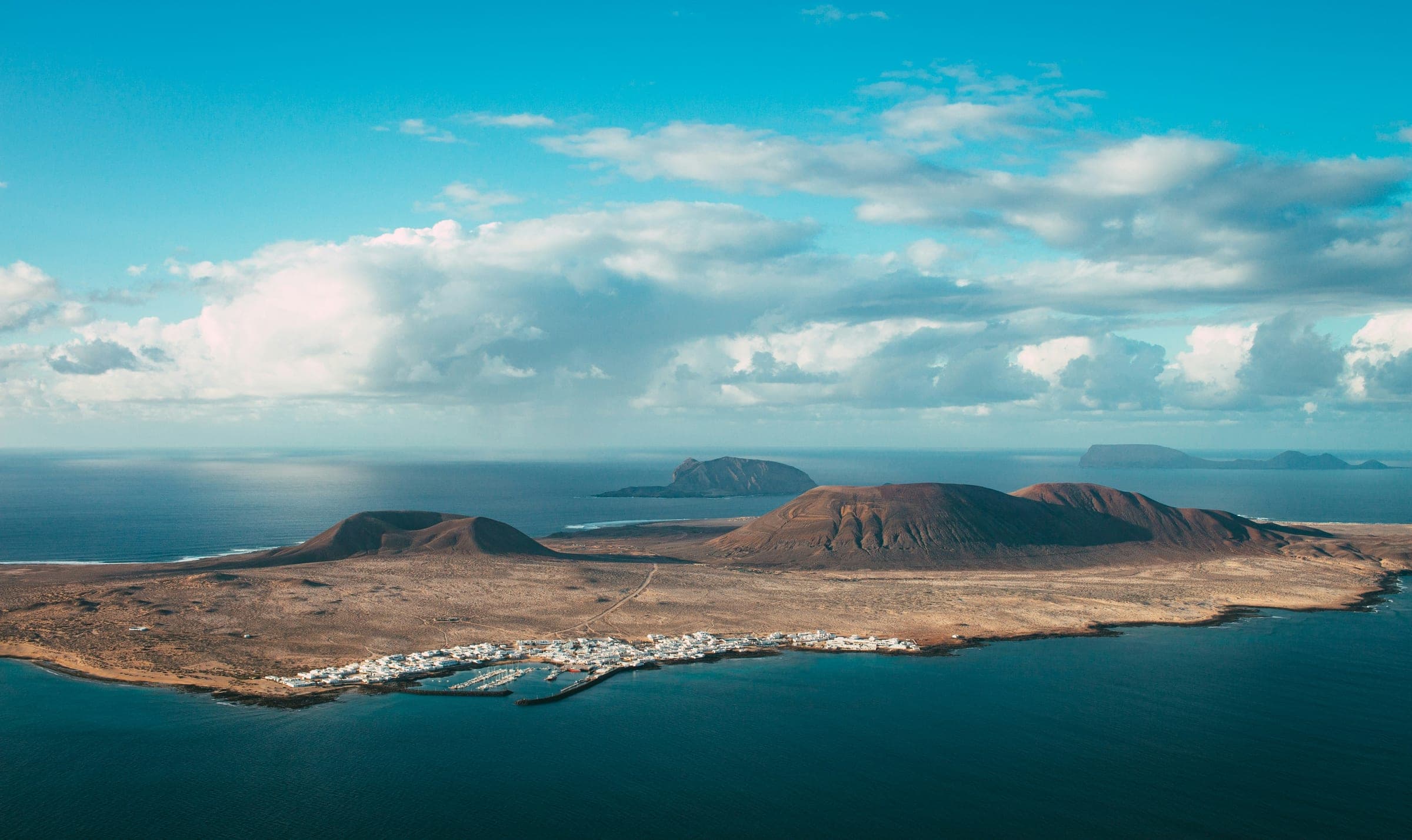 Aerial view of La Graciosa, the small volcanic island off Lanzarote’s northern tip, with its sand-coloured village by the harbour, reached on one of the post-race day trips