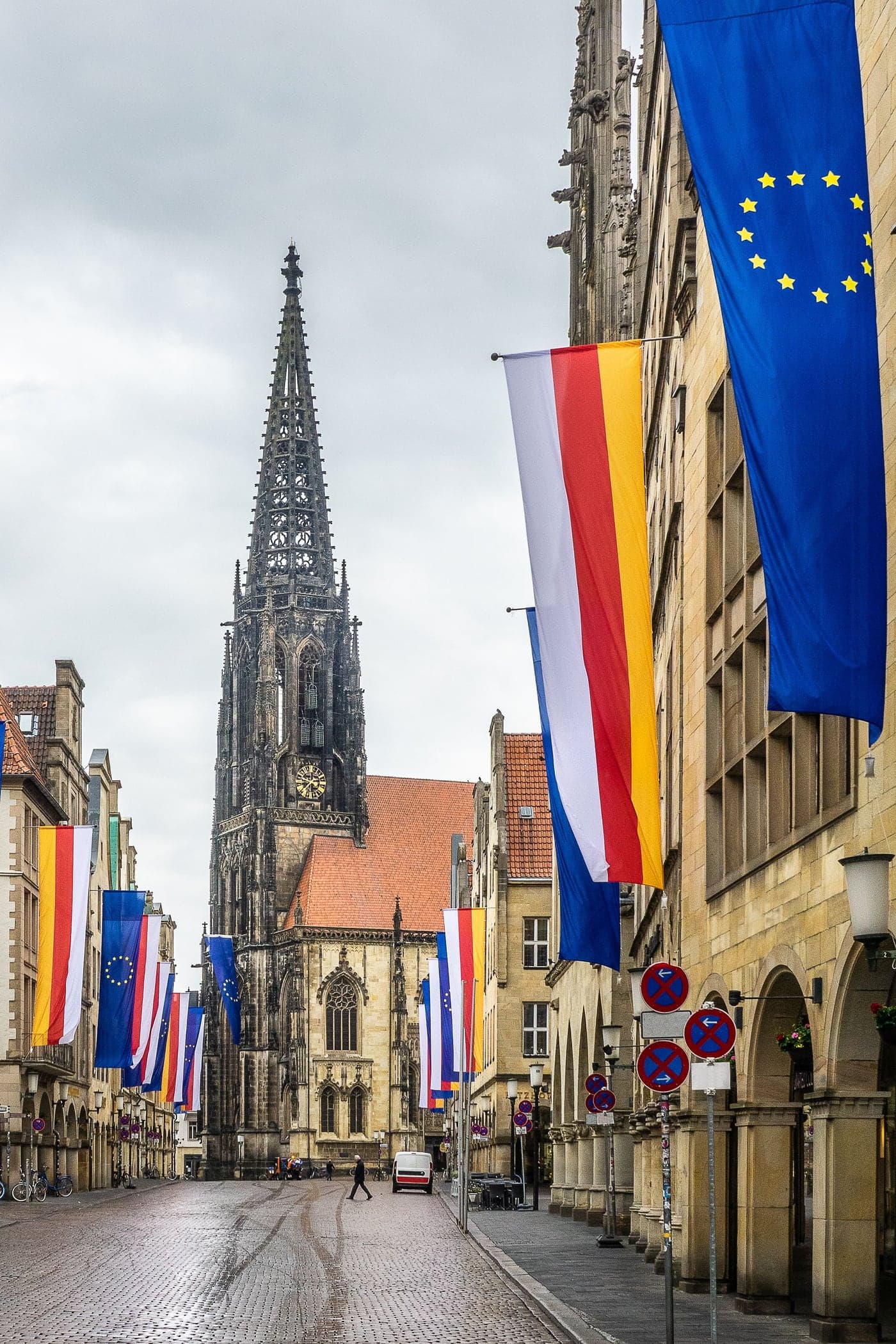 The openwork Gothic tower of St Lamberti seen along a flag-hung Prinzipalmarkt in Münster, a few hundred metres from the marathon finish line