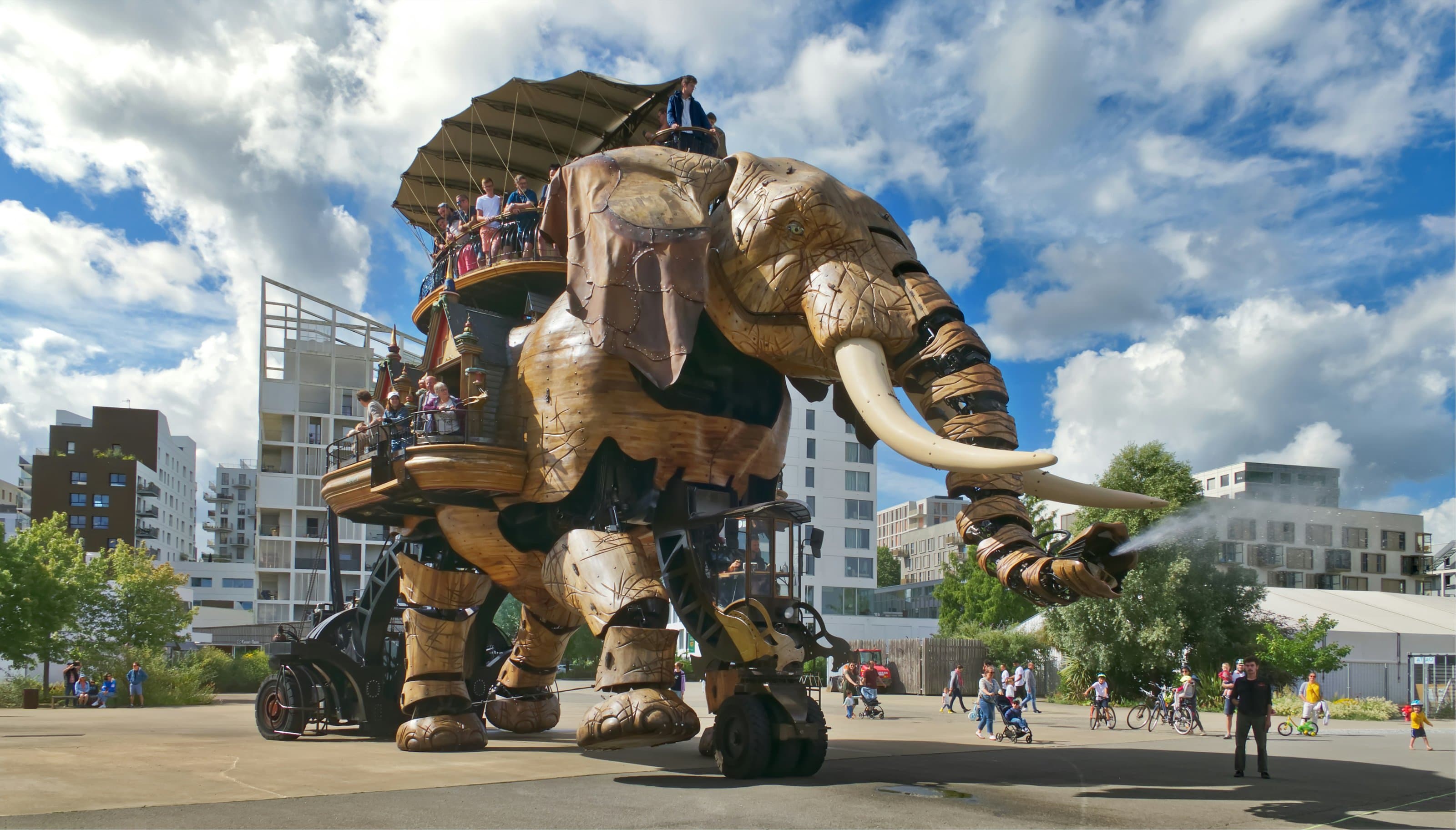 The Grand Éléphant of Les Machines de l’Île, a 12-metre wooden and steel walking elephant carrying passengers on its back and spraying water from its trunk, on the Île de Nantes beside the marathon start