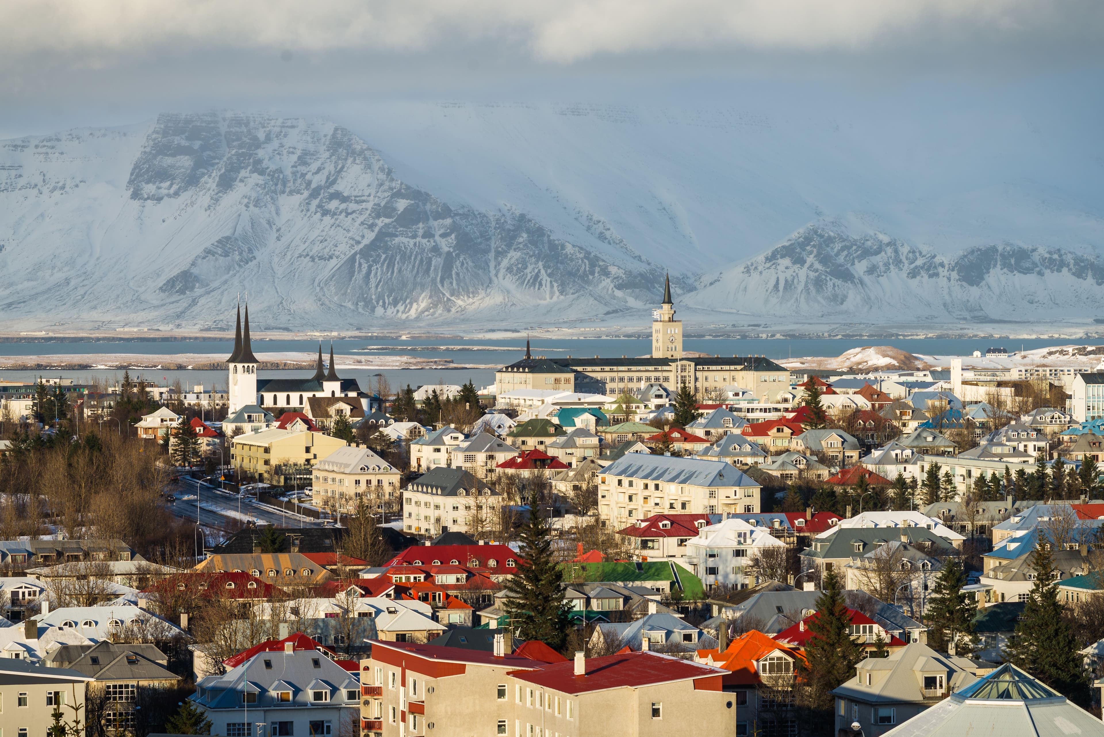 Reykjavik's colourful rooftops with Hallgrímskirkja church and snow-capped mountains across the bay