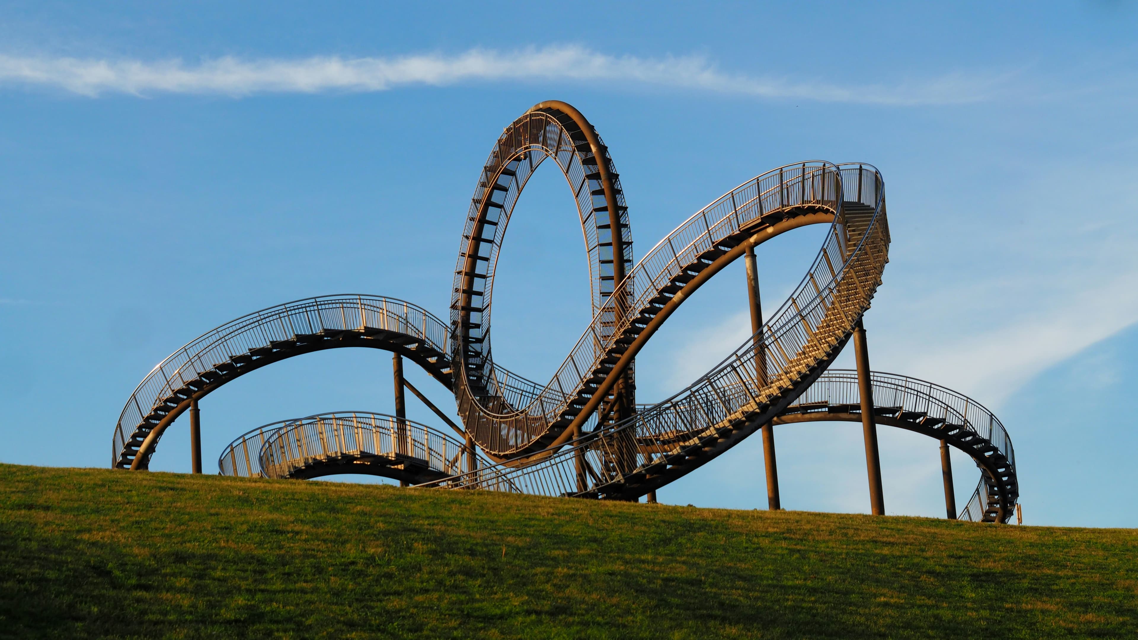 Tiger and Turtle, the walkable steel rollercoaster sculpture on a slag heap in southern Duisburg, against a clear sky. The marathon passes about 1.3 km from it at around km 32.