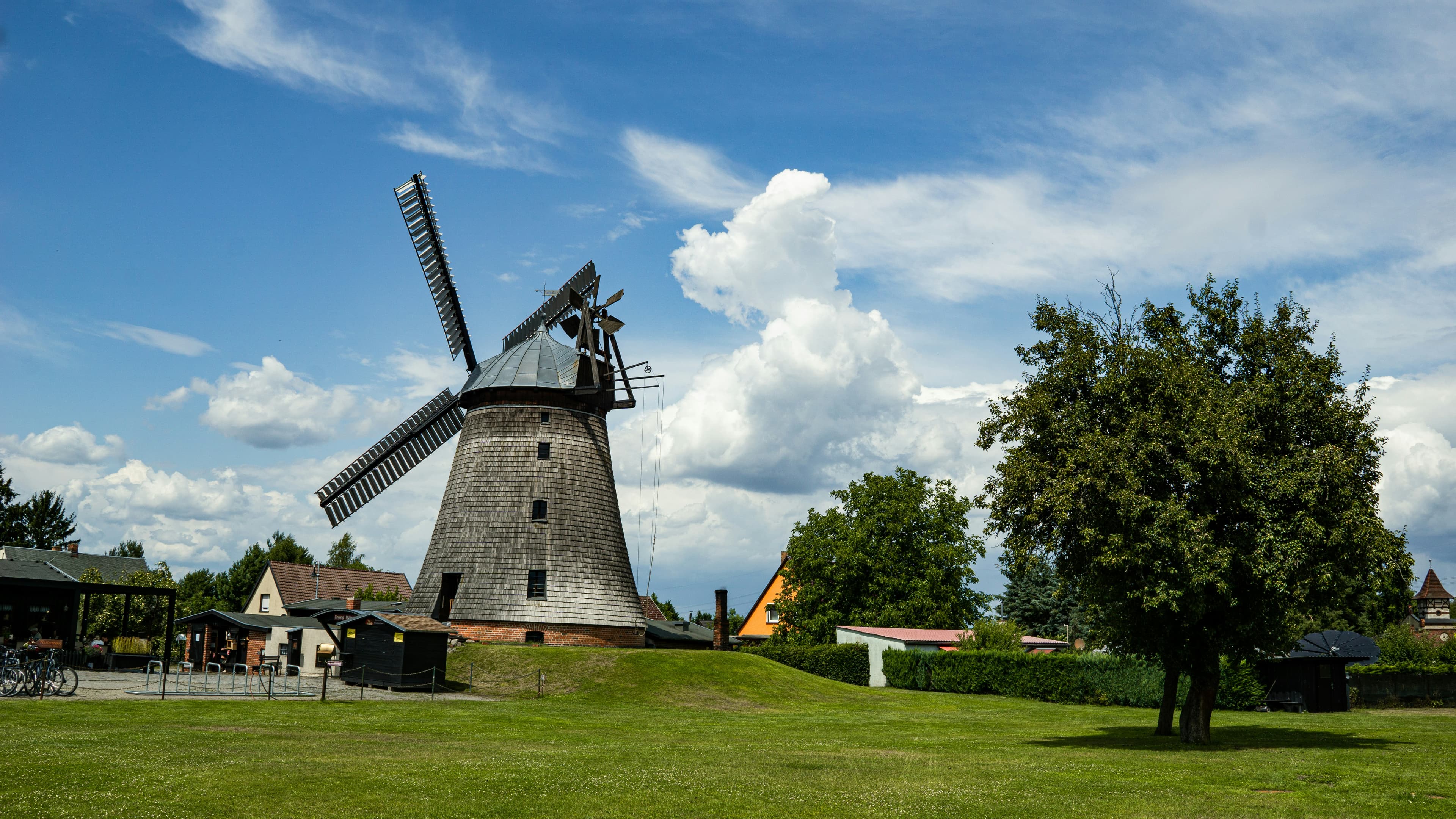 The restored Dutch windmill at Straupitz in the Spreewald, with its sails against a summer sky. Straupitz sits several kilometres north of the retired marathon route.