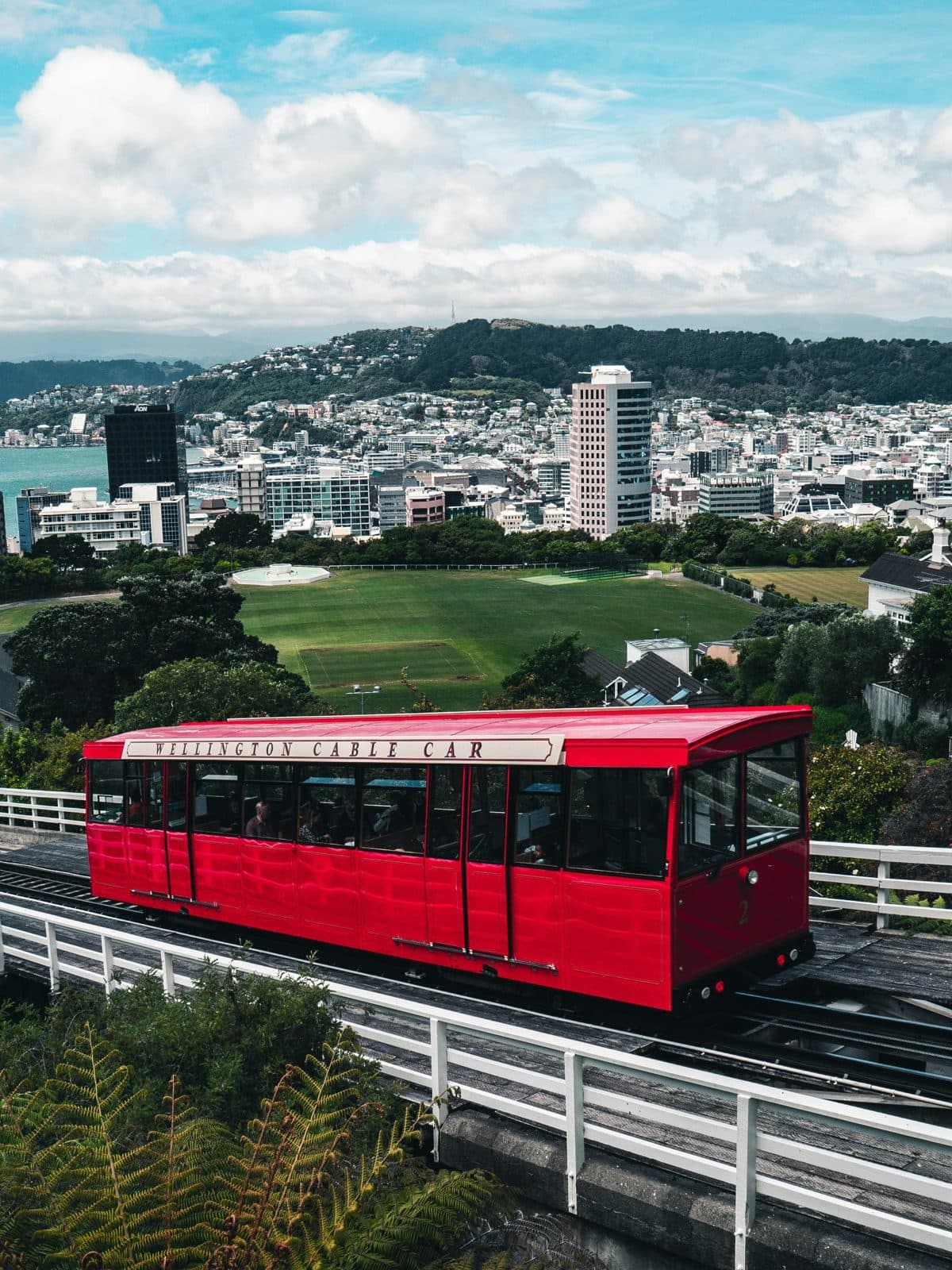 The red Wellington Cable Car carriage on its track above the city, with the harbour and the Miramar hills beyond, a five-minute ride from Lambton Quay