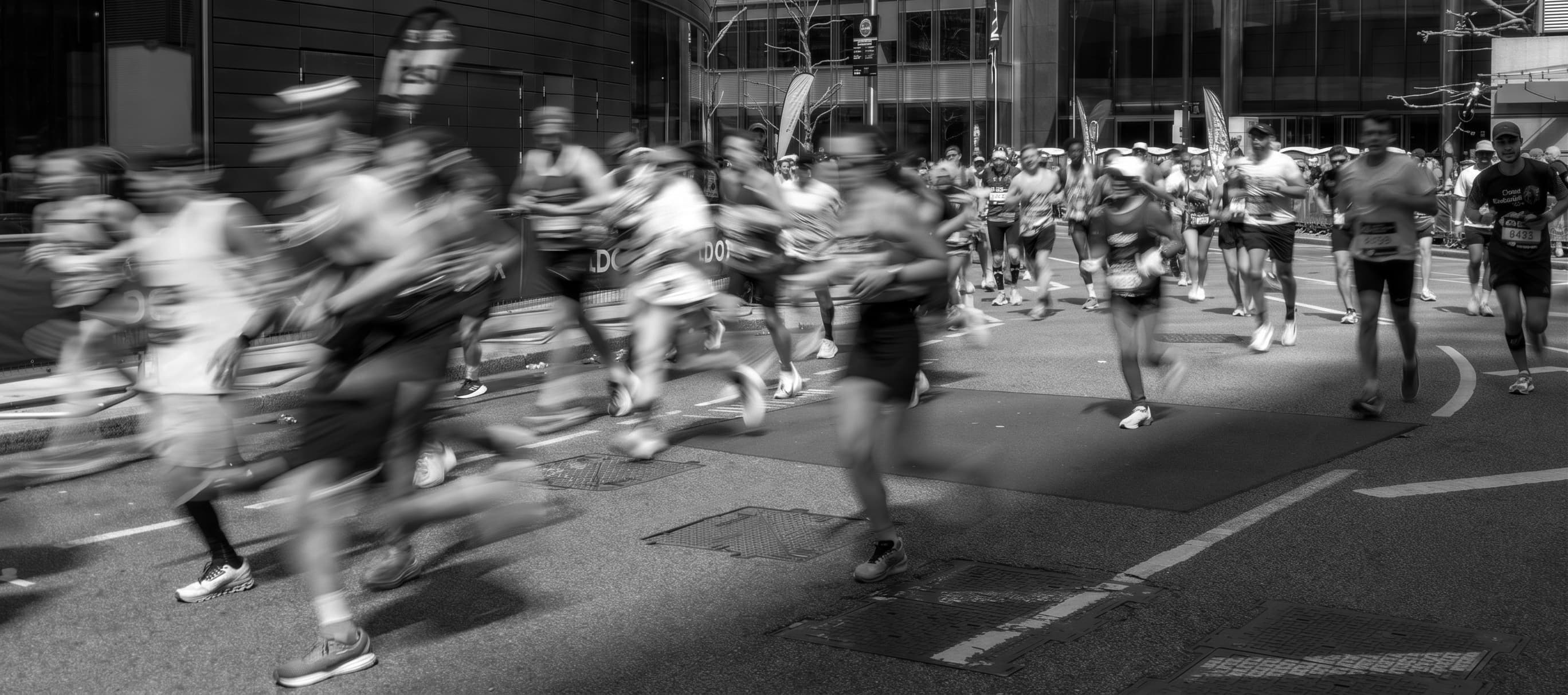 A field of marathon runners in motion at a World Marathon Majors race, rendered with motion blur to convey pace and the scale of the mass-participation field